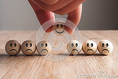 Hand putting on a smiling wooden ball Stock Photo