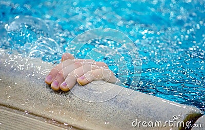 Hand reaches out of a swimming pool Stock Photo