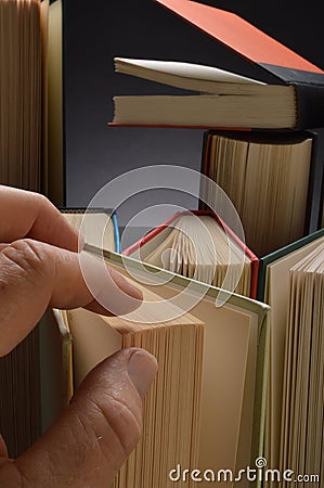 Hand reaching for hardbound book Stock Photo