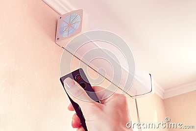 Hand from remote-controlled includes bactericidal air recirculator for quartzing air in room Stock Photo