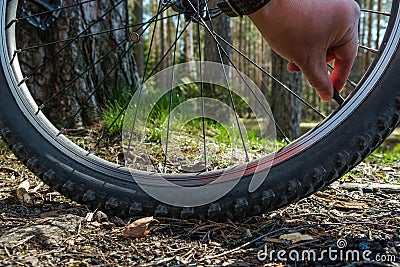 Hand repair bicycle wheel travel crosscounty summer Stock Photo