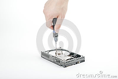 Hand repairman unscrews the cover of the engine of the open 3.5 inch HDD with a screwdriver. Stock Photo