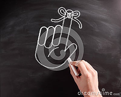 Hand with Ribbon Drawing on Black Chalkboard Stock Photo