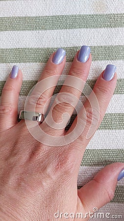 Hand with ring and purple nail polish. Beauty fashion photo. Stock Photo