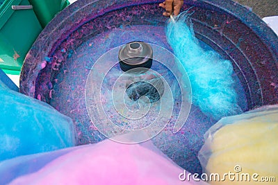 Hand rolling cotton candy in candy floss machine. Candyfloss making Stock Photo