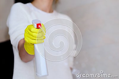 Hand in rubber gloves spraying detergent in bathroom Stock Photo