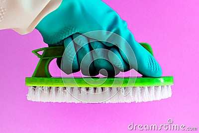 Hand in rubber latex glove with Handheld floor brush cleaning in on pink background Stock Photo