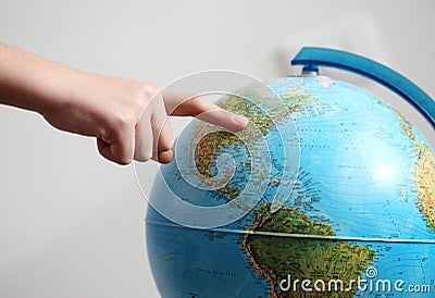 Hand's child pointing on a globe Stock Photo