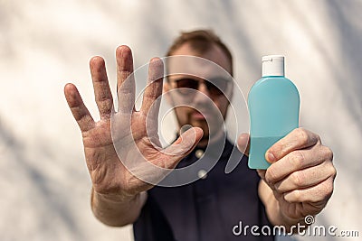 Hand sanitizer alcohol gel rub clean hands hygiene prevention of coronavirus virus outbreak. Man showing one hand and holding a Stock Photo