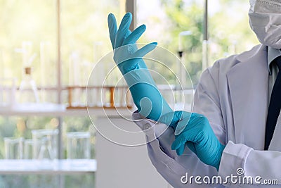 Scientist or doctor putting blue latex gloves in laboratory. Safety work concept Stock Photo