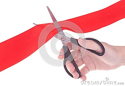 Hand with scissors cutting red ribbon Stock Photo