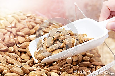 Scoop takes almond nuts in store Stock Photo