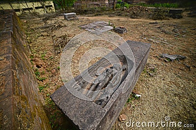 Hand sculpted figurine of a deity on a stone slab lying on the ground at Udayagiri Buddhist Archaelogical Site Odisha, India. Stock Photo