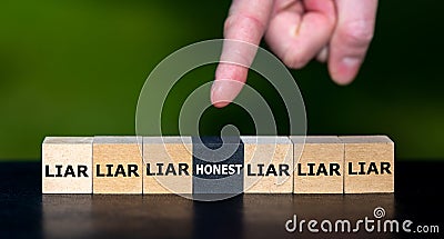 Hand selects the cube with the word 'honest' instead of cubes with the word 'liar'. Stock Photo