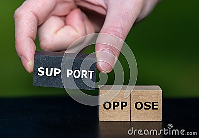 Hand selects wooden cubes with the word support instead of cubes with the word oppose Stock Photo