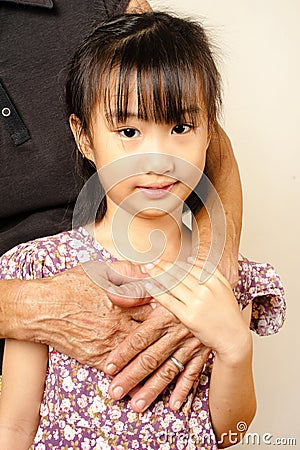 Hand of senior hugging with her child. Asian llttle girl embrace Stock Photo