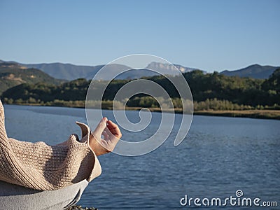 Hand senior woman yoga and lotus pose meditation and relax in the mountan lake. Healthy and Zen Concept Close up Stock Photo