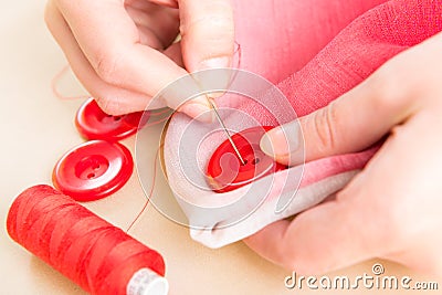 Hand sewing button on fabric Stock Photo