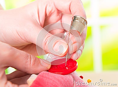 Hand sewing button on fabric Stock Photo