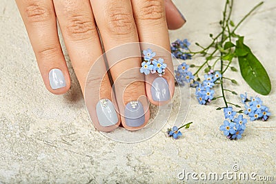 Hand with short manicured nails colored with gray nail polish Stock Photo