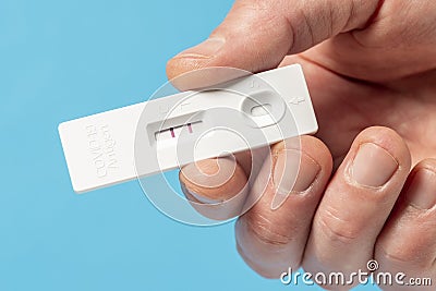 Hand showing Covid-19 positive test result with SARS CoV-2 Rapid antigen test kit Stock Photo