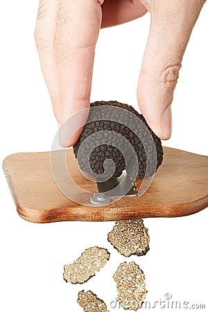 Hand slicing black truffle with wooden truffle slicer Stock Photo