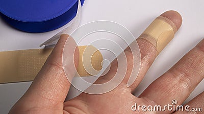 Hand with slight wound that is cured with sanitary tape to prevent infection, first aid application Stock Photo