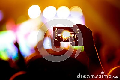 Hand with a smartphone records live music festival, Taking photo of concert stage Stock Photo