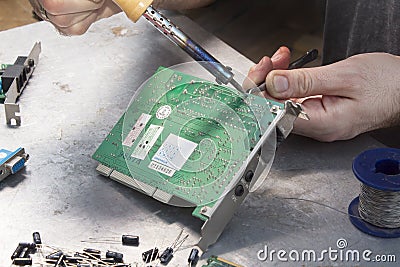 Hand of a soldering soldier with soldering iron. Stock Photo