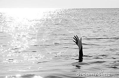 hand of man drowning in the ocean with black and white effect Stock Photo