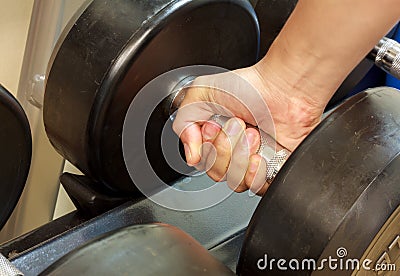 Hand someone holding dumbell in gym. Stock Photo