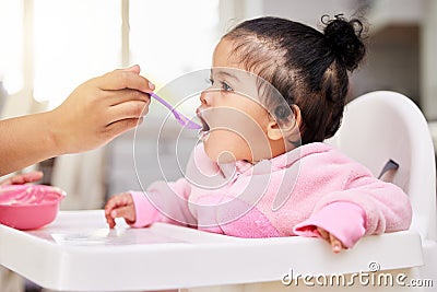 Hand, spoon and child food in chair for baby development, nutrition meal or dinner snack. Kid, feed and eating breakfast Stock Photo