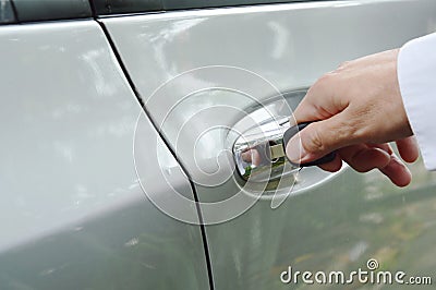 Hand stabbing car key in handle hole and twist for open door Stock Photo