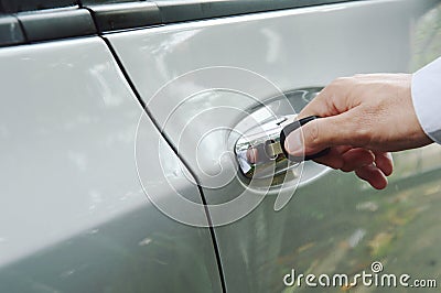 Hand stabbing car key in handle hole and twist for open door Stock Photo