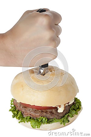 Hand stabbing a hamburger Stock Photo