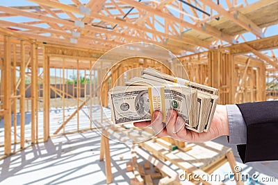 Hand With Stacks of Cash On Site Inside New Home Construction Fr Stock Photo