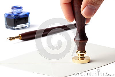 Hand With a Stamp on a Letter Envelope Stock Photo