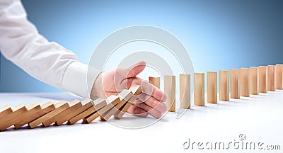 Hand Stopping Domino Effect Stock Photo