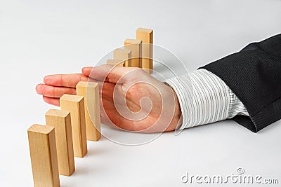 Hand stopping dominoes falling Stock Photo
