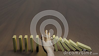 Hand stopping falling dominos from business crisis Stock Photo