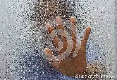Hand of stranger on frosted glass with water drop Stock Photo