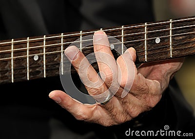Hand strumming guitar strings Stock Photo