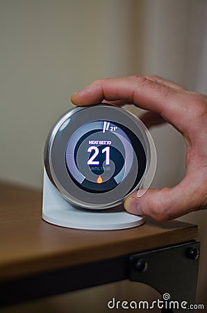 hand switching Controlling Thermostat with Digital Temperature Display Stock Photo