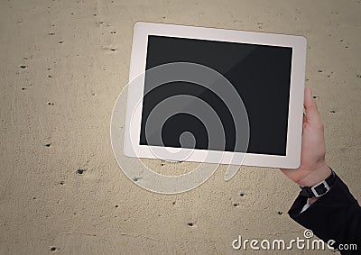 Hand with tablet against sand Stock Photo