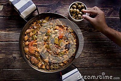 Hand tasting olives and Spanish paella Stock Photo