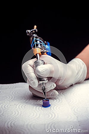 Hand of a professional tattoo artist with a tattoo machine. Stock Photo