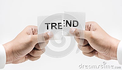 Hand tearing paper with TREND word in white tone background. Stock Photo