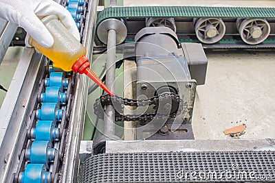 The hand of technician lubricating oil drops to chain drive for maintenance Stock Photo