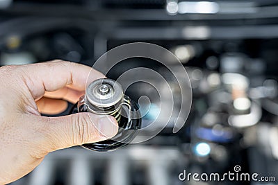 Hand a technician take of Car thermostat in engine room and check water heating Stock Photo