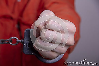 THE HAND OF A TEENAGER IN HANDCUFFS. Concept: juvenile delinquent, criminal liability of minors. Members of youth criminal groups Stock Photo